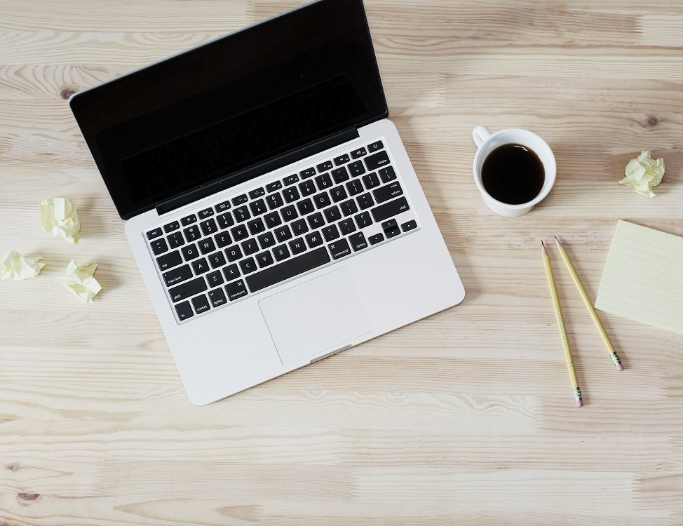 Laptop mit Kaffeetasse Stift und Notizen